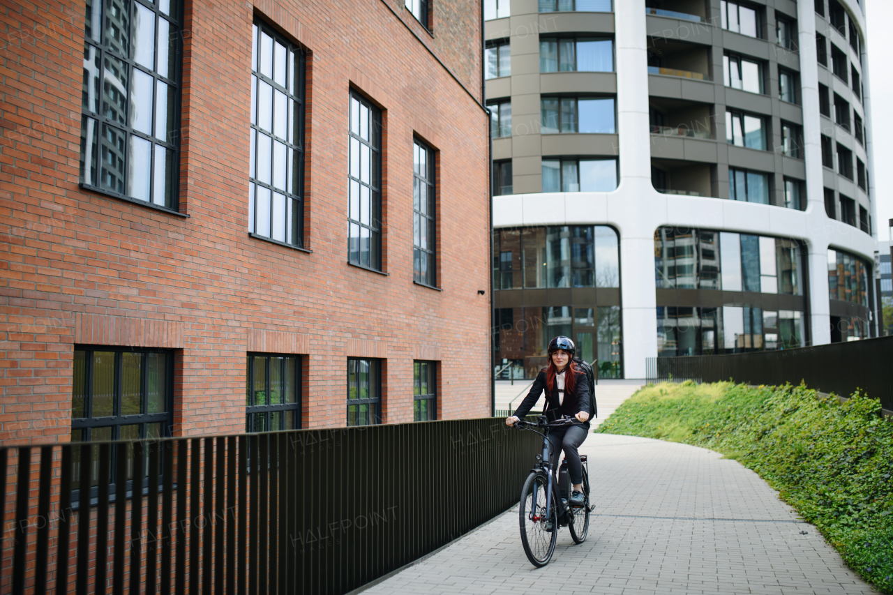 A businesswoman commuter on the way to work with bike, sustainable lifestyle concept.