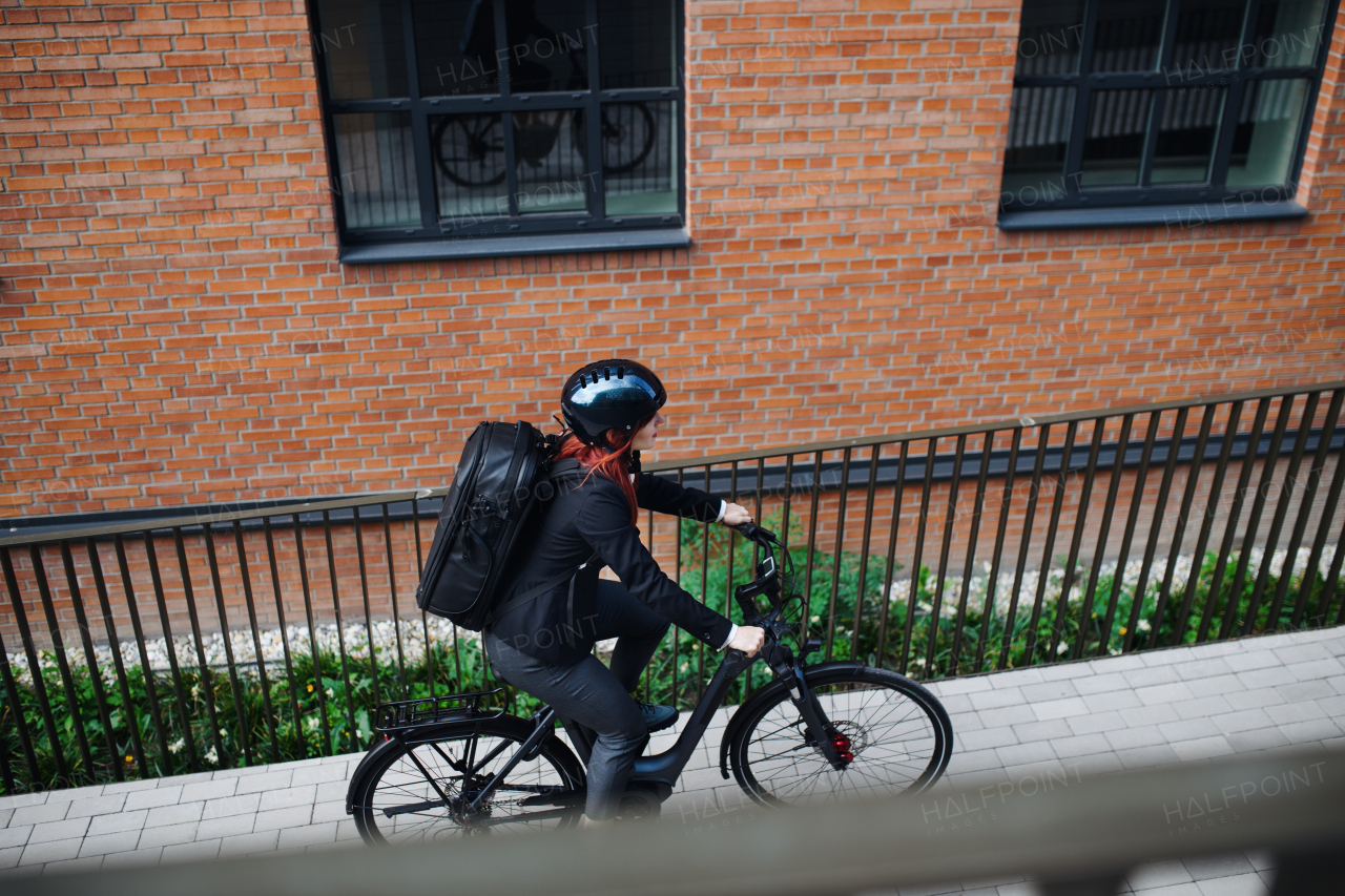 A businesswoman commuter on the way to work with bike, sustainable lifestyle concept. High angle view.