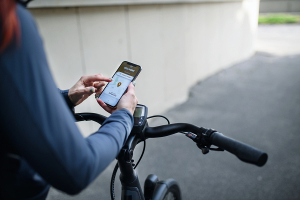 A courier riding a bicycle and looking on the cellphone asnd using delivery app, sustainable transport concept