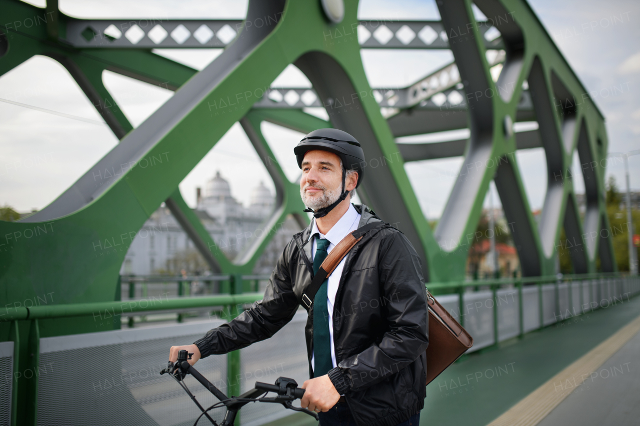 A businessman commuter on the way to work, riding bike over bridge, sustainable lifestyle concept.