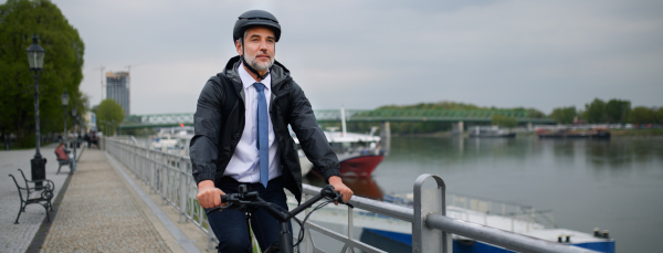 A businessman commuter on the way to work, riding bike in city, sustainable lifestyle concept.