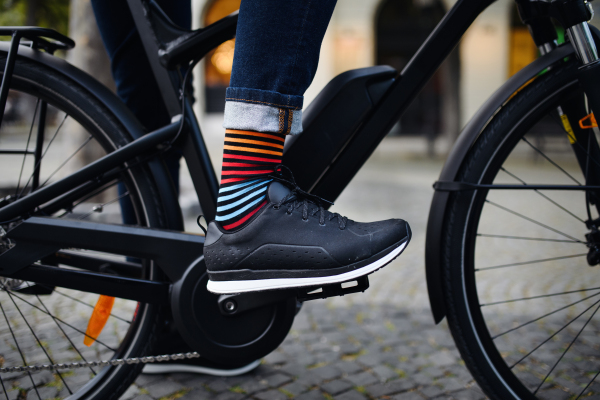 Businessman commuter on a way to work, close up of his legs riding bicycle.