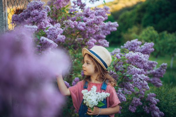 Portrait of a little girl with lilac, spring mood.