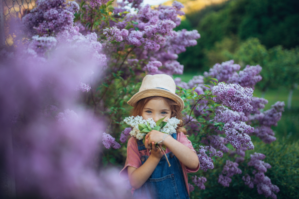 Portrait of a little girl with lilac, spring mood.