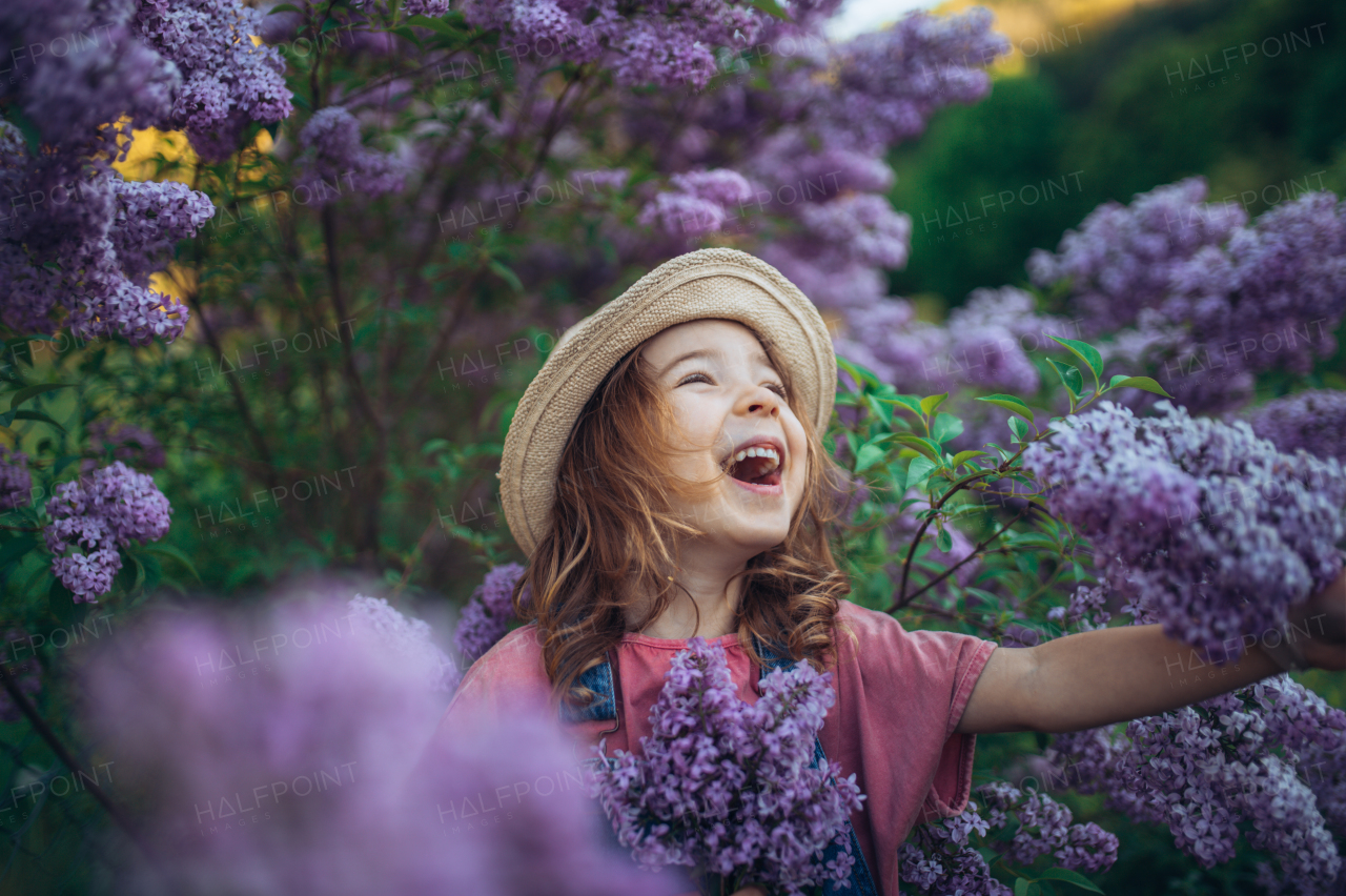 Portrait of a little girl with lilac, spring mood.