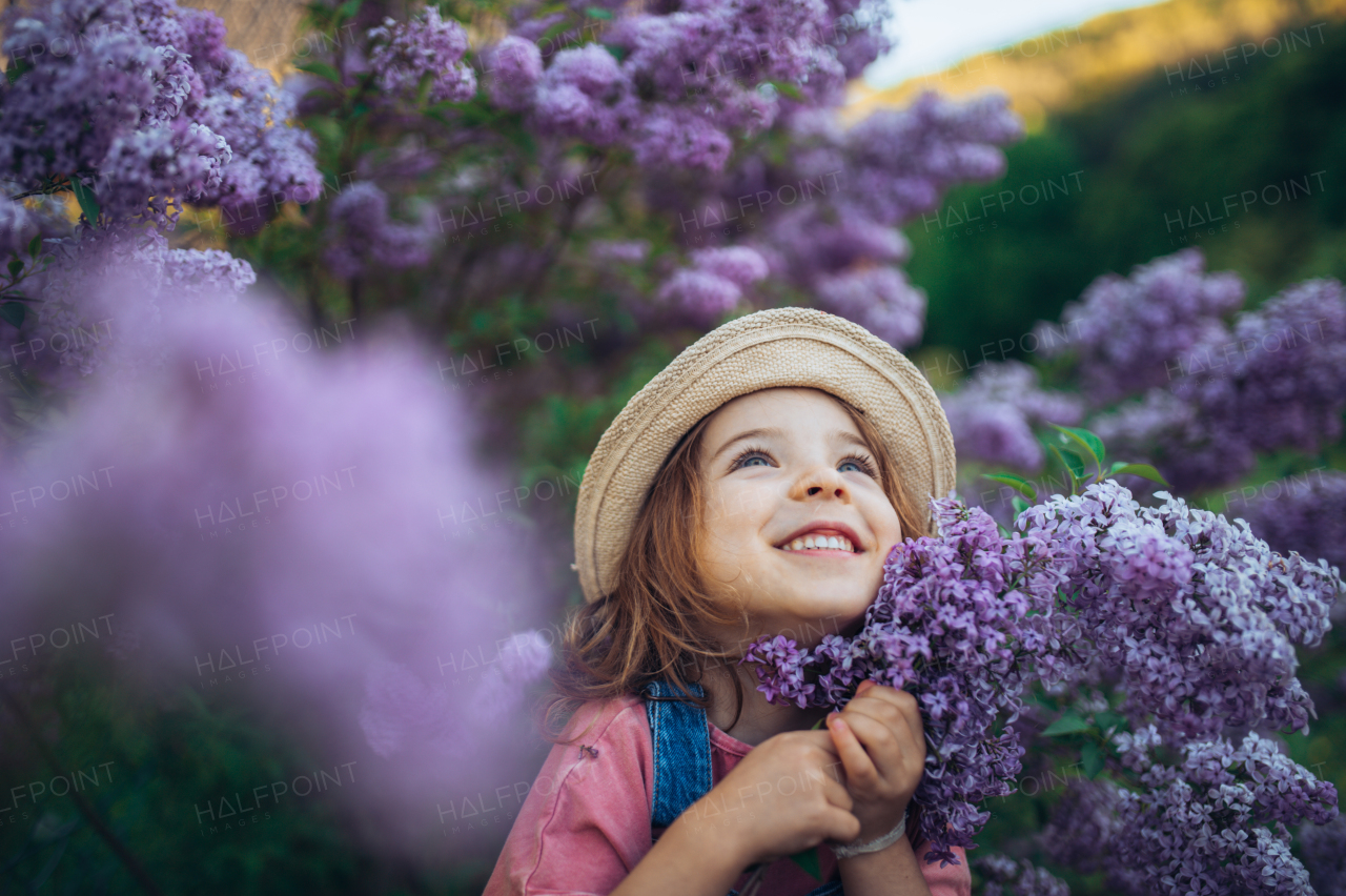 Portrait of a little girl with lilac, spring mood.