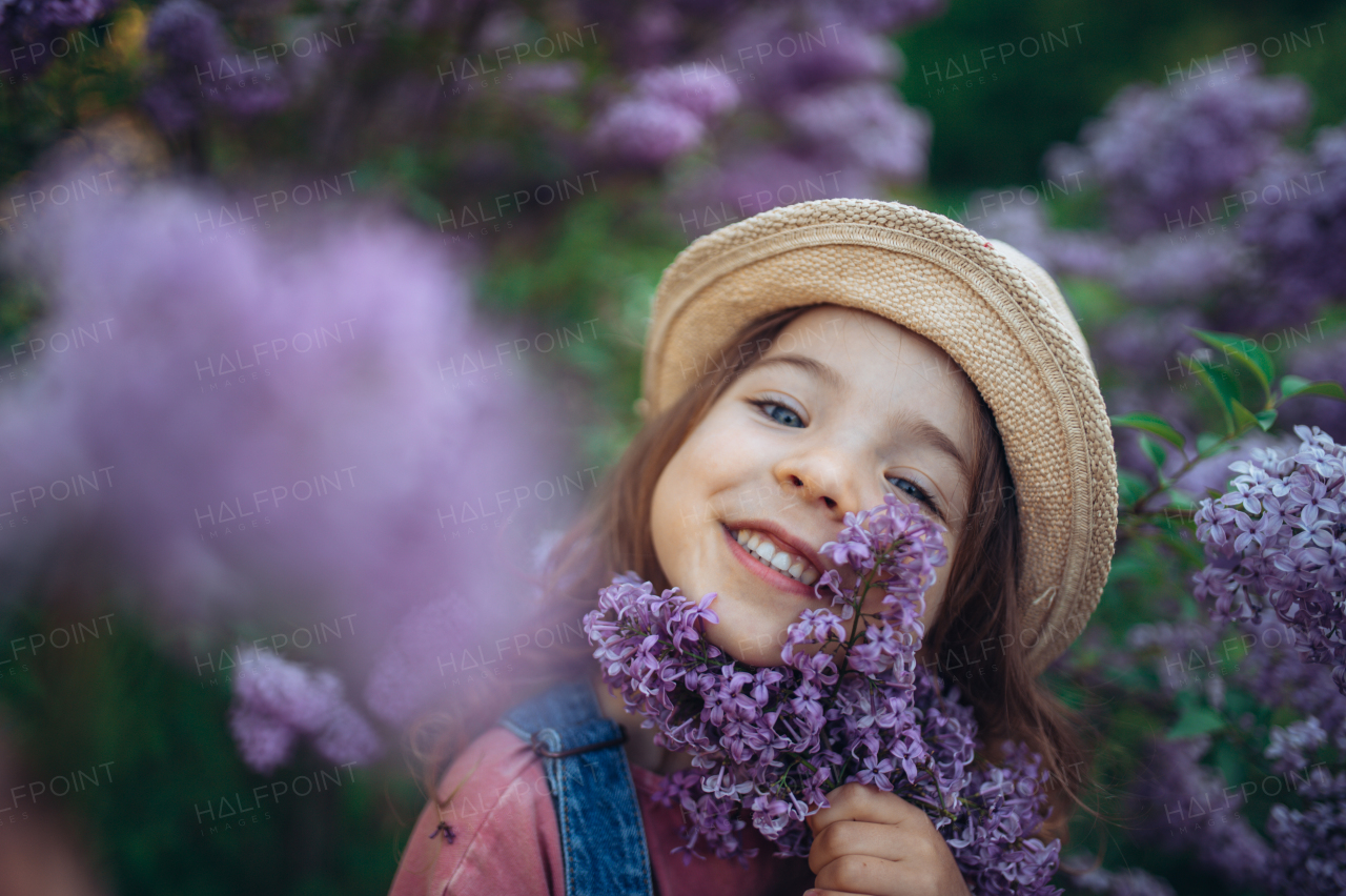 Portrait of a little girl with lilac, spring mood.