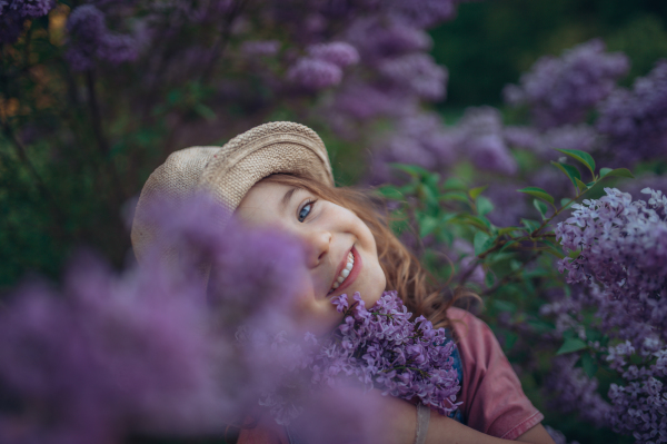 Portrait of a little girl with lilac, spring mood.