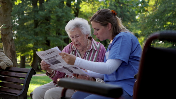 Video of a nurse on a walk in a public park with patients, resting on bench.