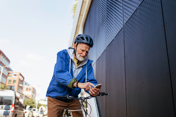 An elderly man, cyclist traveling through the city by bike. Senior city commuter riding a bike to grocery store.