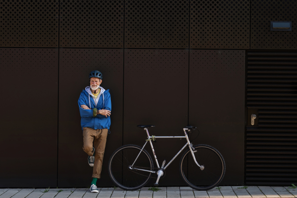 An elderly man, cyclist traveling through the city by bike. Vital senior city commuter riding a bike, exercising.