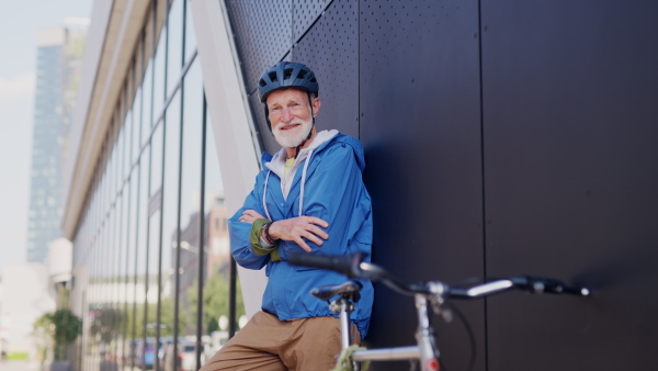 An elderly man, cyclist traveling through the city by bike. Vital senior city commuter riding a bike, exercising.