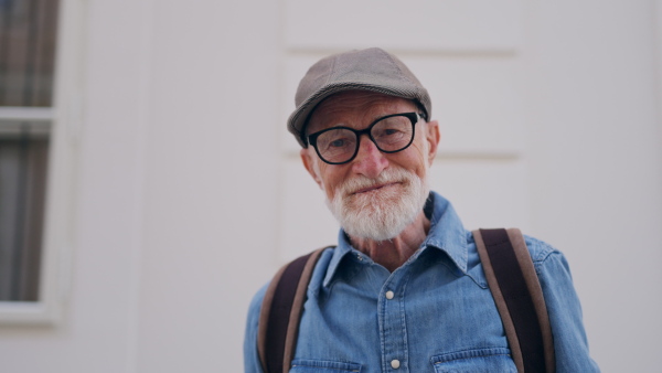 Video of handsome senior man in the city. An elderly independent man with backpack visiting new city. Traveling and solo trips in retirement.