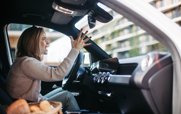 Upset woman driving her car in city.