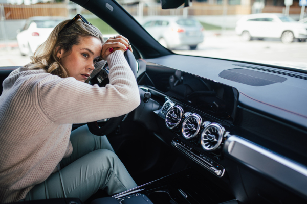 Portrait of young tired woman sleeping in a car, concept of safety and driving.