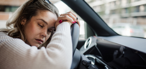 Portrait of young tired woman sleeping in a car, concept of safety and driving.