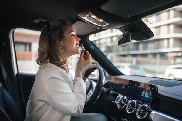 Happy woman driving her new electric car in a city.