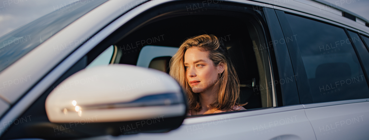 Happy woman driving her new electric car in a city.