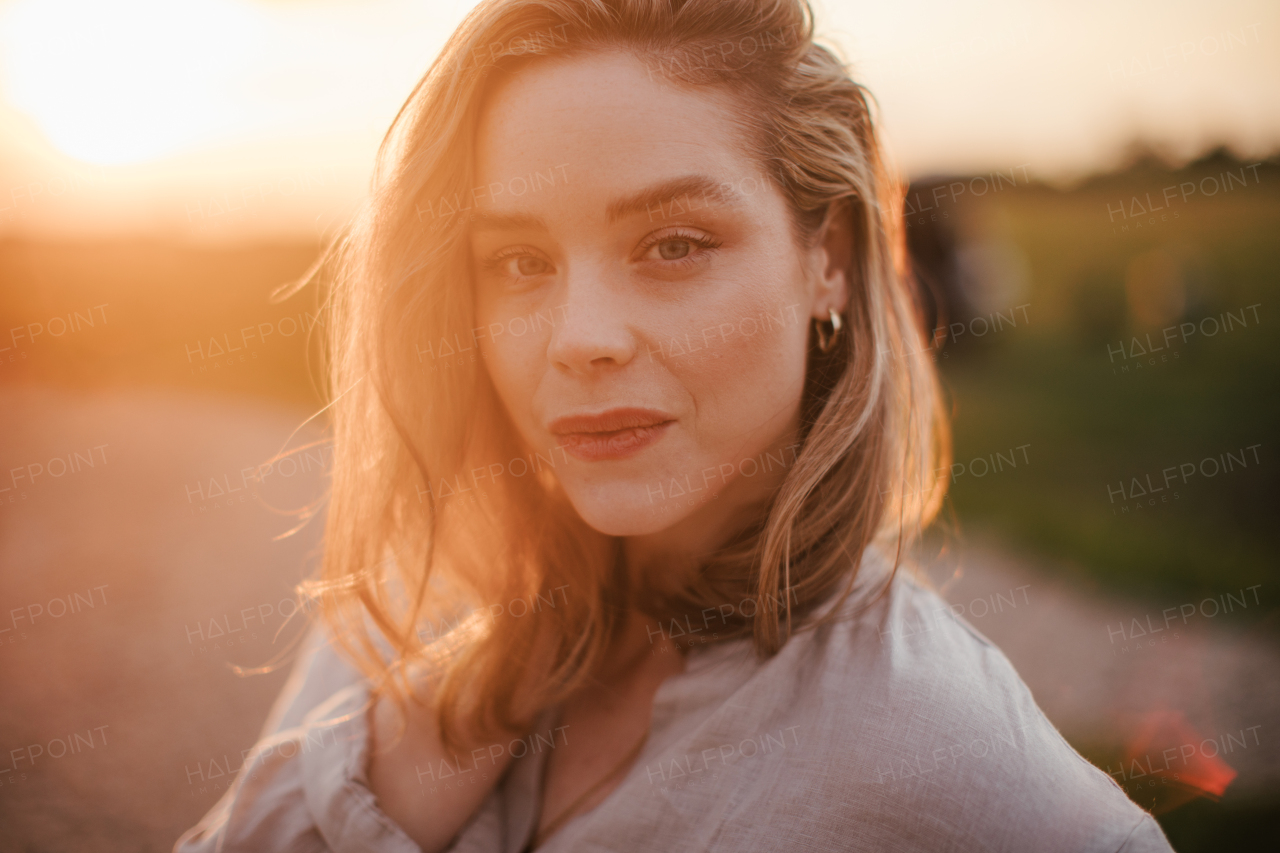 Portrait of young woman walking near the lake, enjoying summer time.