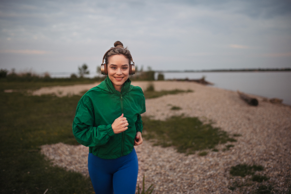 Young woman runing outdoor, near a lake.