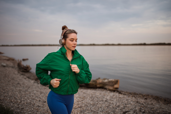 Young woman runing outdoor, near a lake.