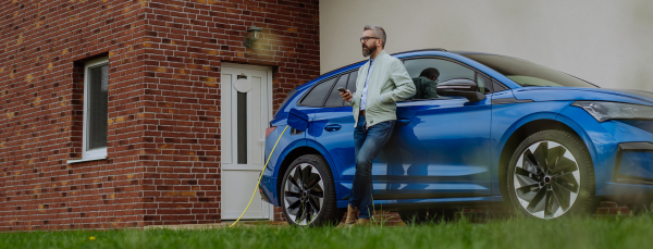 Mature businessman waiting for charging his new electric car.