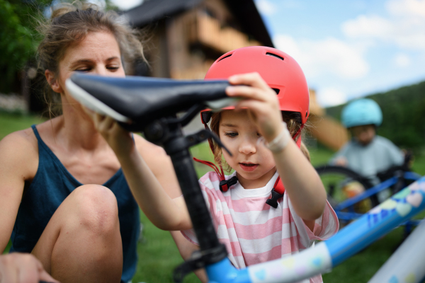 A young family with little children preaparing for bike ride in front of house.