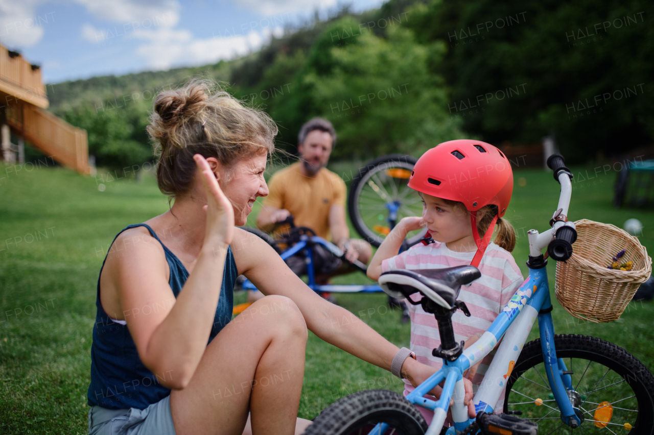 A young family with little children preaparing for bike ride, in front of house.