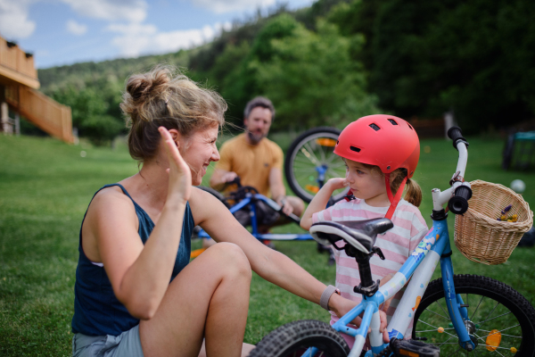 A young family with little children preaparing for bike ride, in front of house.