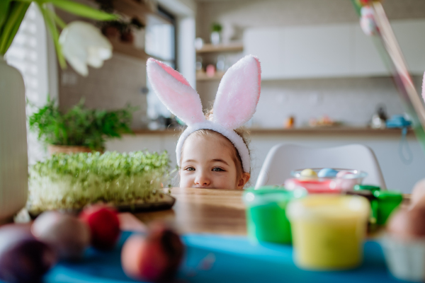 Little girl with bunny ears enjoying easter time in their home.