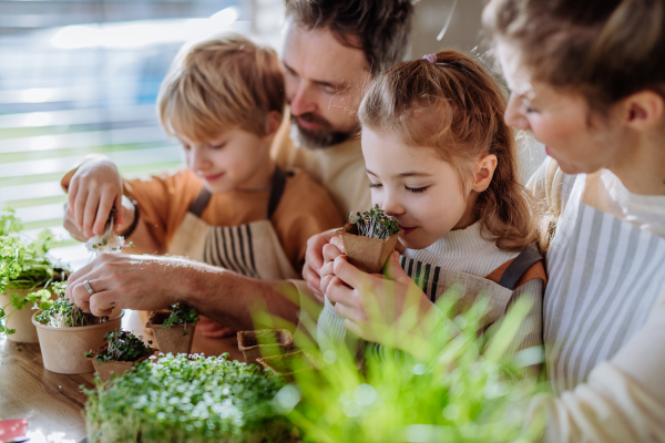 Happy family planting herbs together during spring.