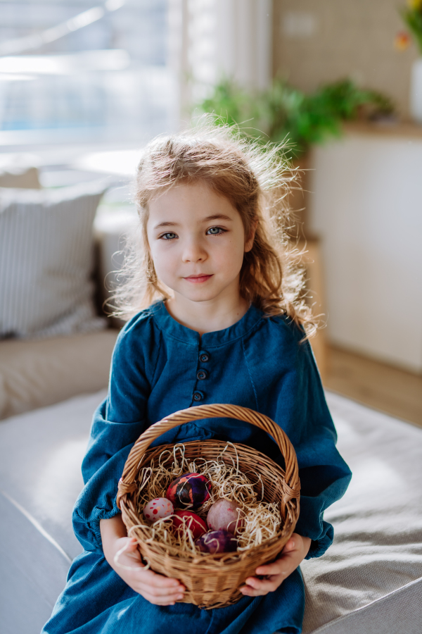 Portrait of little girl holding basket with the easter eggs.