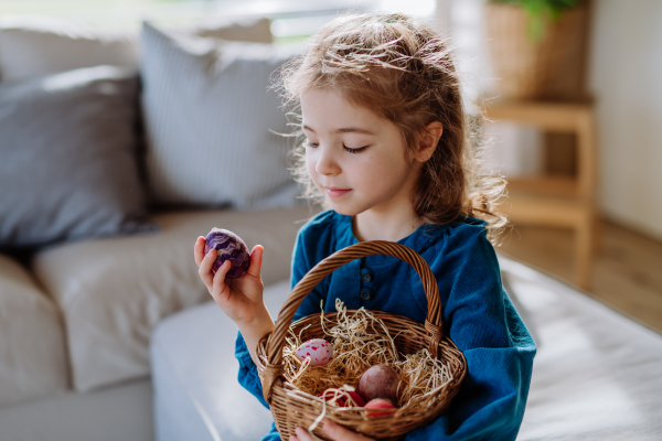 Portrait of little girl holding basket with the easter eggs.