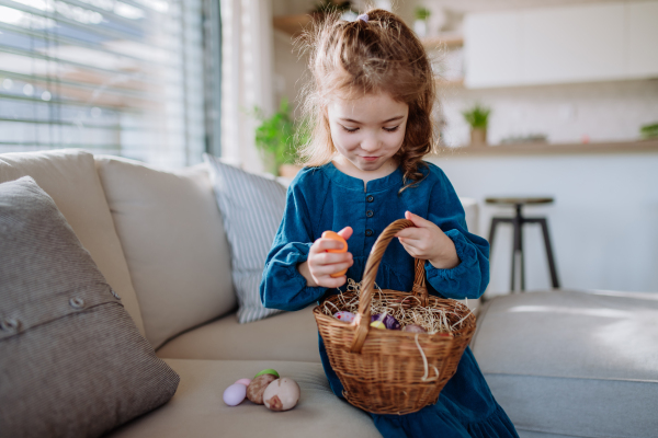 Portrait of little girl holding basket with the easter eggs.