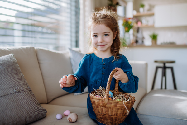 Portrait of little girl holding basket with the easter eggs.