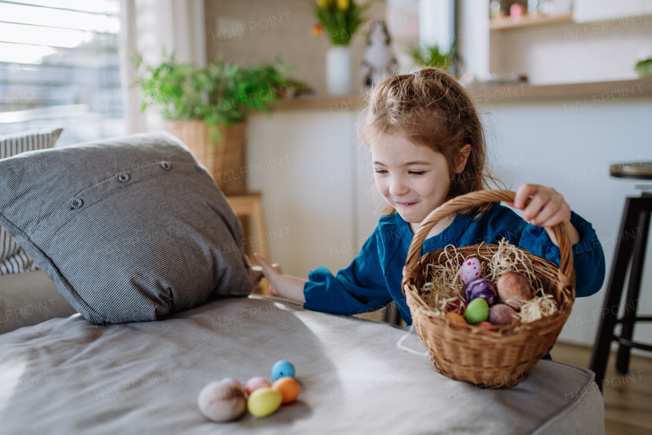 Happy little girl looking for easter eggs in their home.