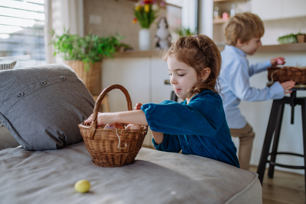 Happy little children looking for easter eggs in their home.