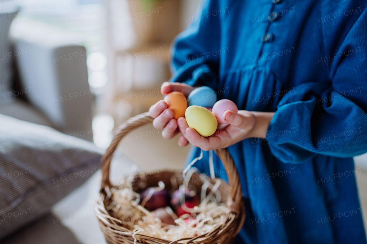 Close-up of little girl holding basket with the easter eggs.