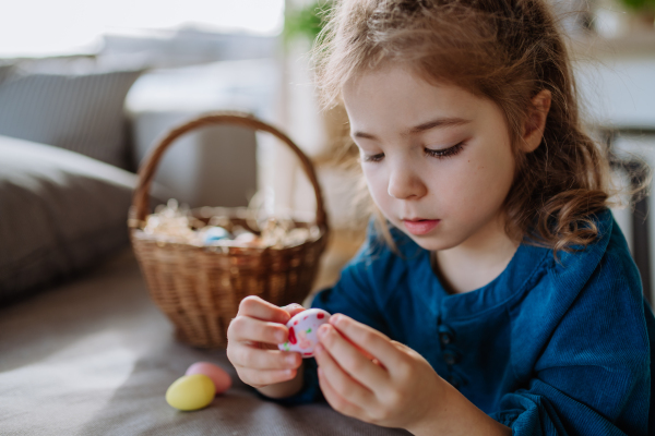 Happy little girl looking for easter eggs in their home.