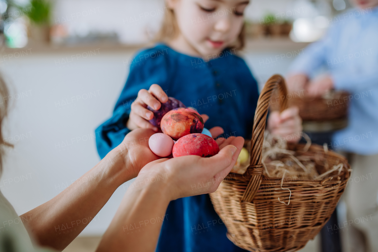 Little girl holding basket and showing mother easter eggs which she found.