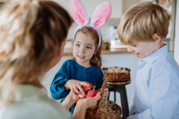 Little girl holding basket and showing mother easter eggs which she found.