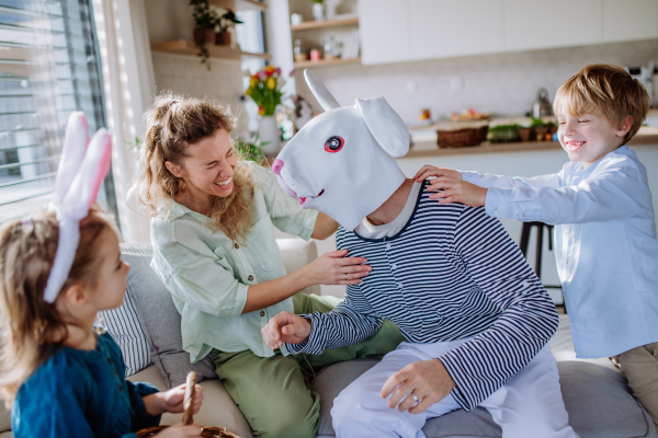 Little children having fun with her mum and Easter rabbit, celebrating Easter.