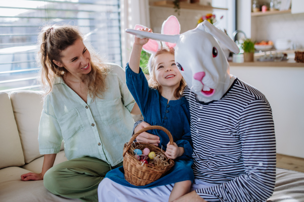 Little girl having fun with her mum and Easter rabbit, celebrating Easter.