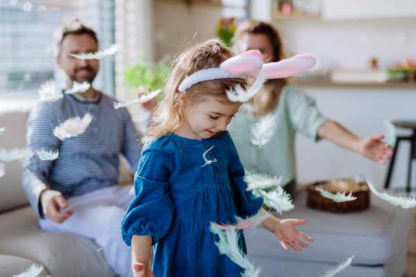 Little girl with the bunny ears celebrating Easter with her parents.