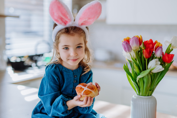 Little girl holding an easter pastries, celebrating easter and spring.