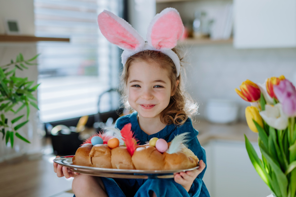 Little girl holding an easter pastries, celebrating easter and spring.