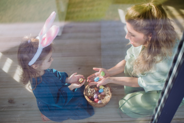 Little girl holding basket and showing mother easter eggs which she found.