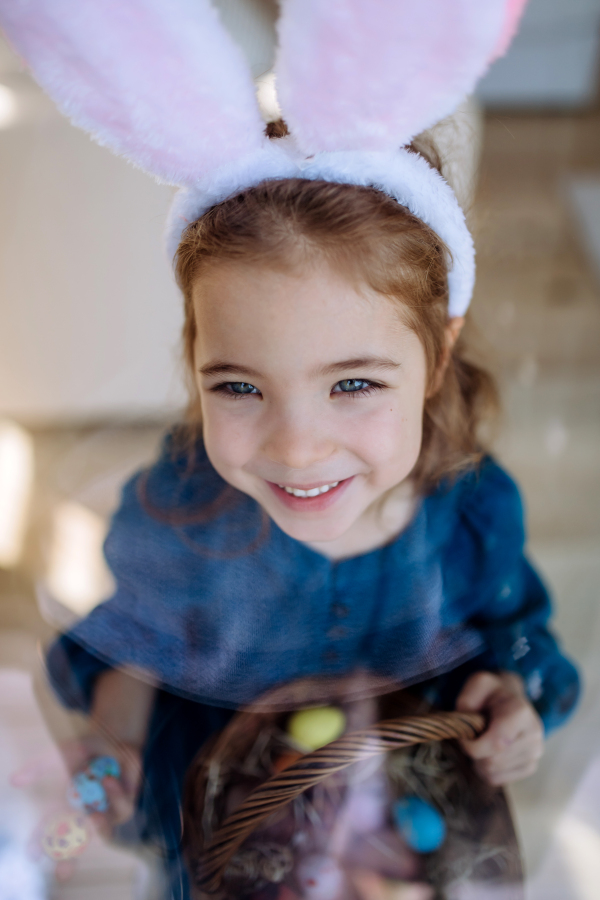 Portrait of little girl holding basket with the easter eggs.