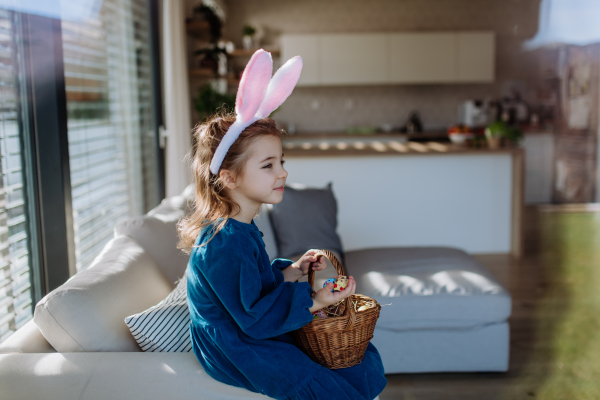 Portrait of little girl holding basket with the easter eggs.