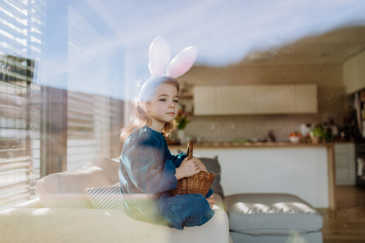 Portrait of little girl holding basket with the easter eggs.